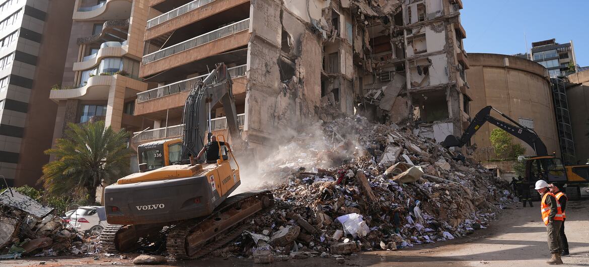 Heavy machinery clears rubble from a building destroyed by airstrikes in Beirut, Lebanon.